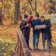 Travel, hiking, adventure concept. Group of young friends hiking in autumn colorful forest, looking at map and planning hike.